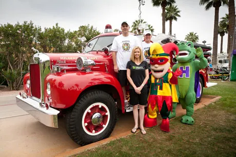 Doctor and staff of Hilgers Pediatric Dentistry in front of an old fire engine 