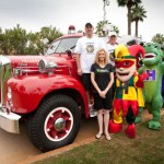 Doctor and staff of Hilgers Pediatric Dentistry in front of an old fire engine 