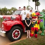 Doctor and staff of Hilgers Pediatric Dentistry in front of an old fire engine 